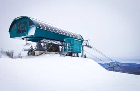 green ski lift building in snow