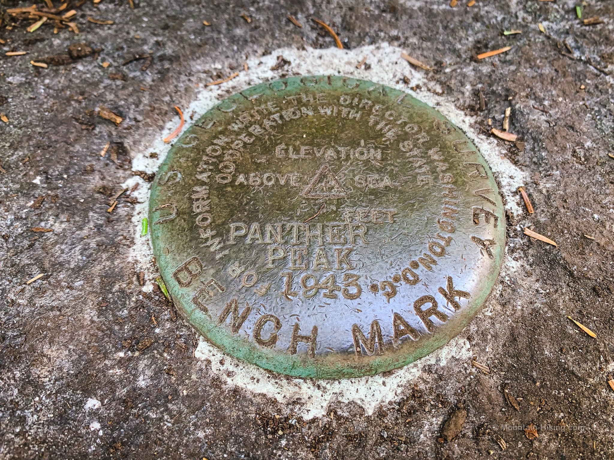 summit marker embedded in rock