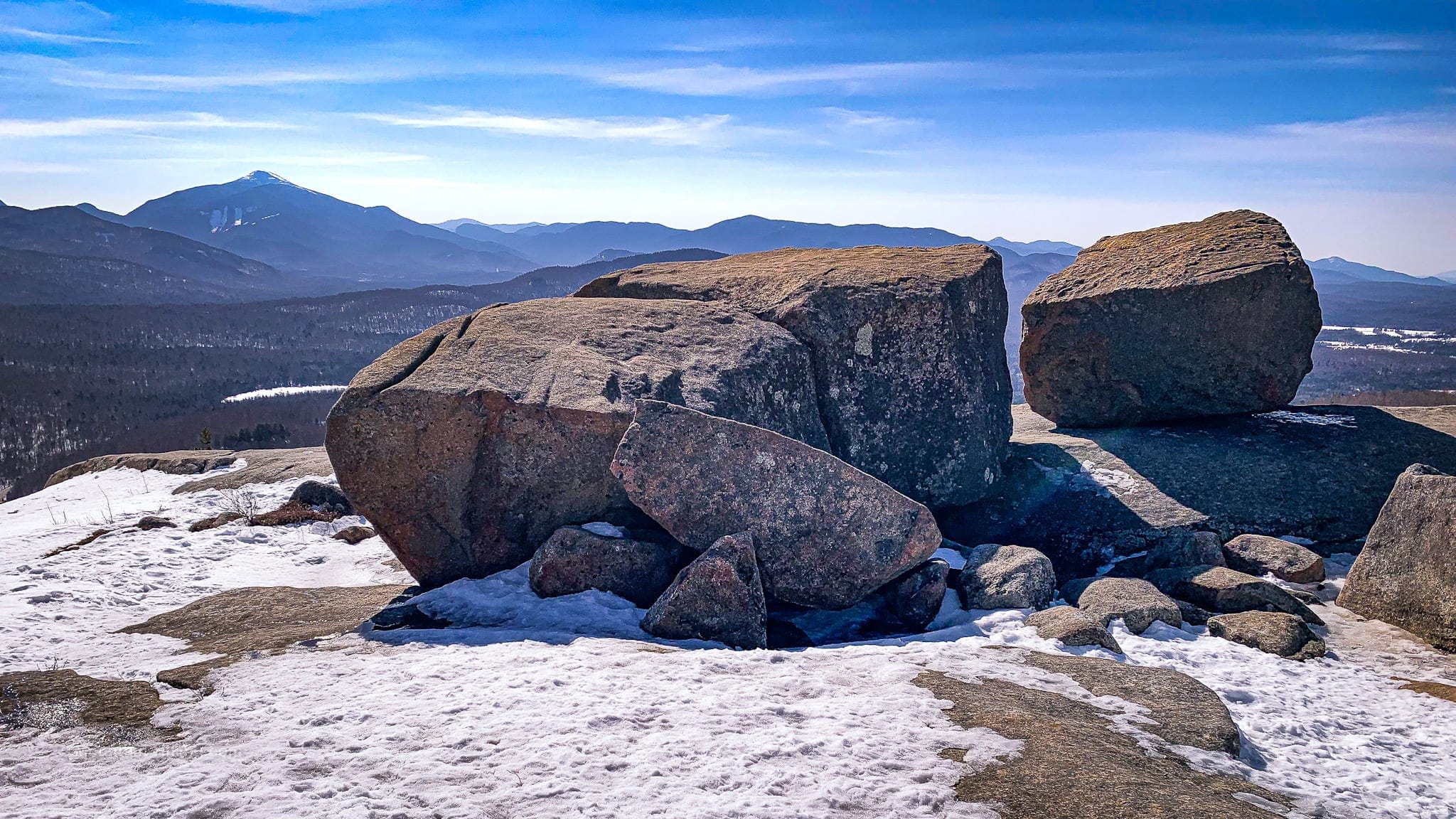 large glacial erratic boulders with mountain summits behind