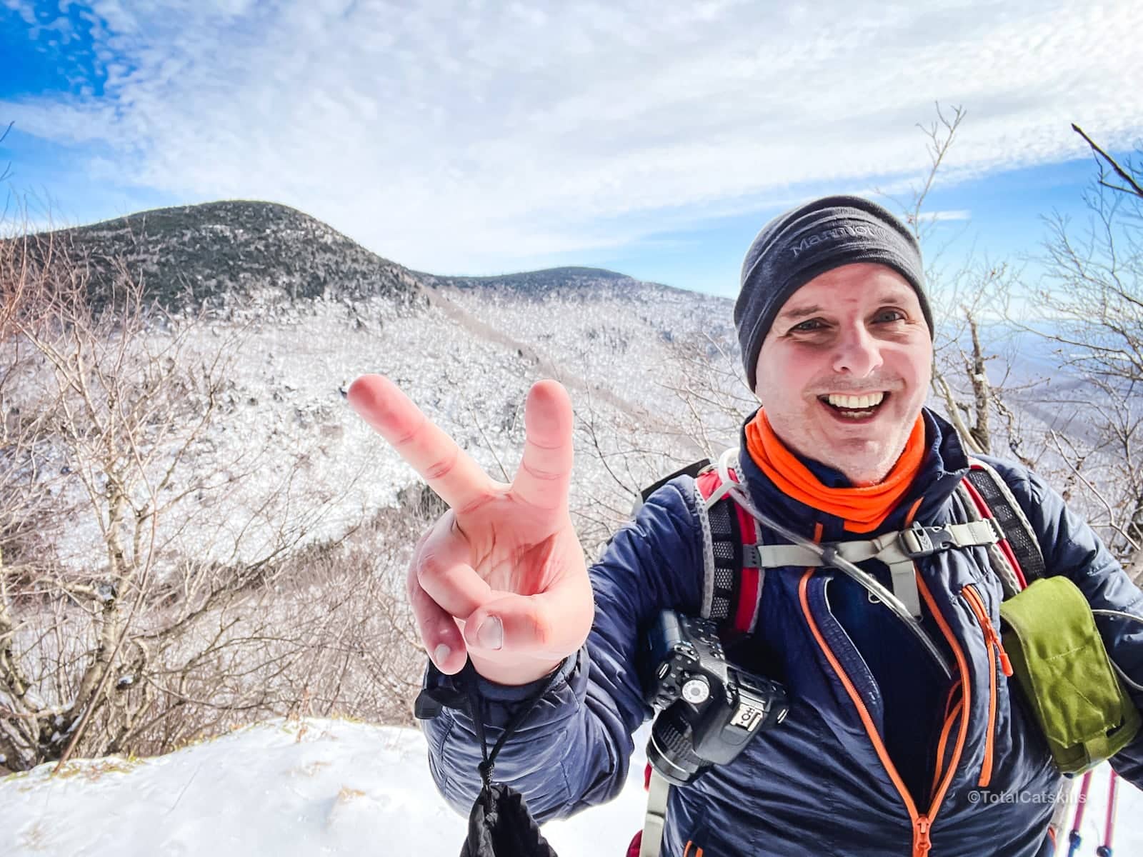 Hiker showing two fingers on a snowy mountain