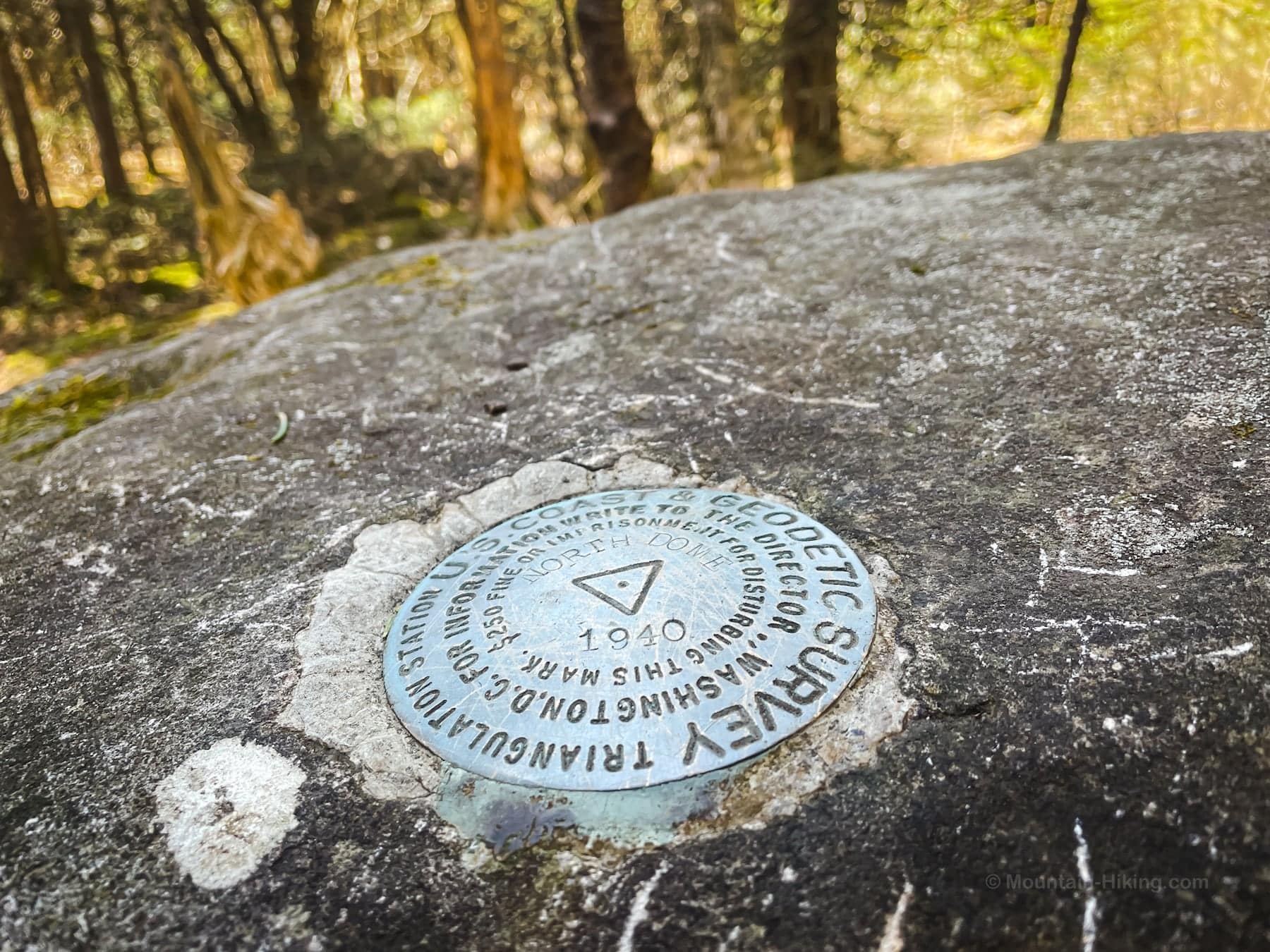 survey marker embedded in boulder