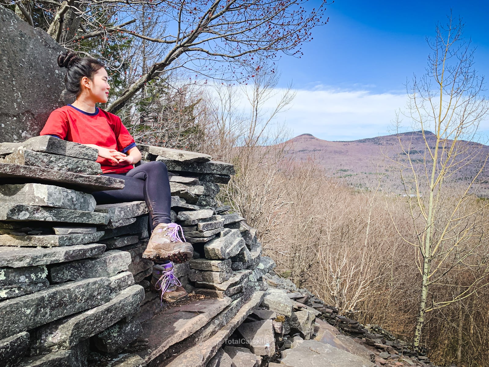 hiker sits comfortably on a rock chair in Dibbles Quarry