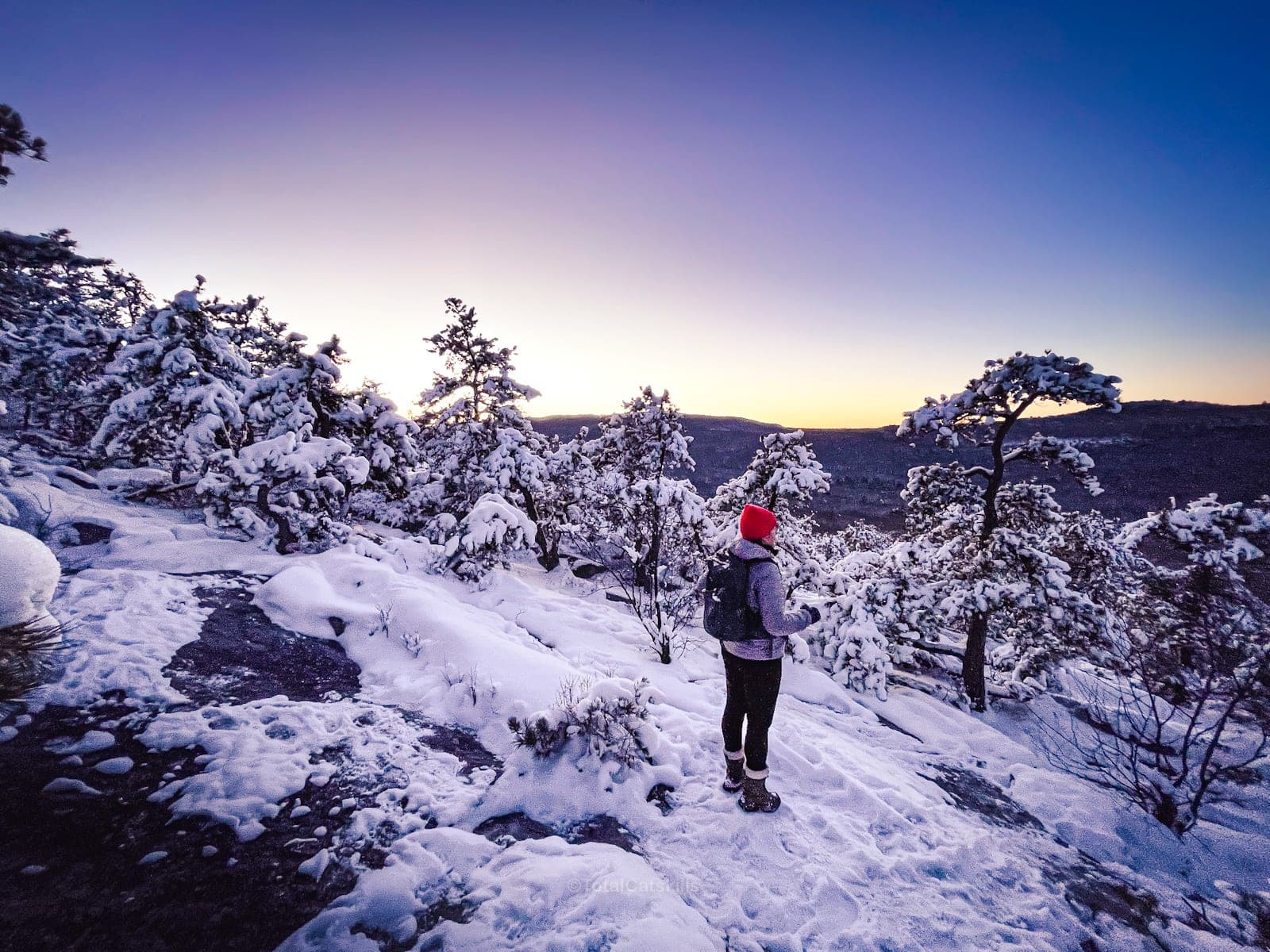 Hiker standing in snow on mountain ridge