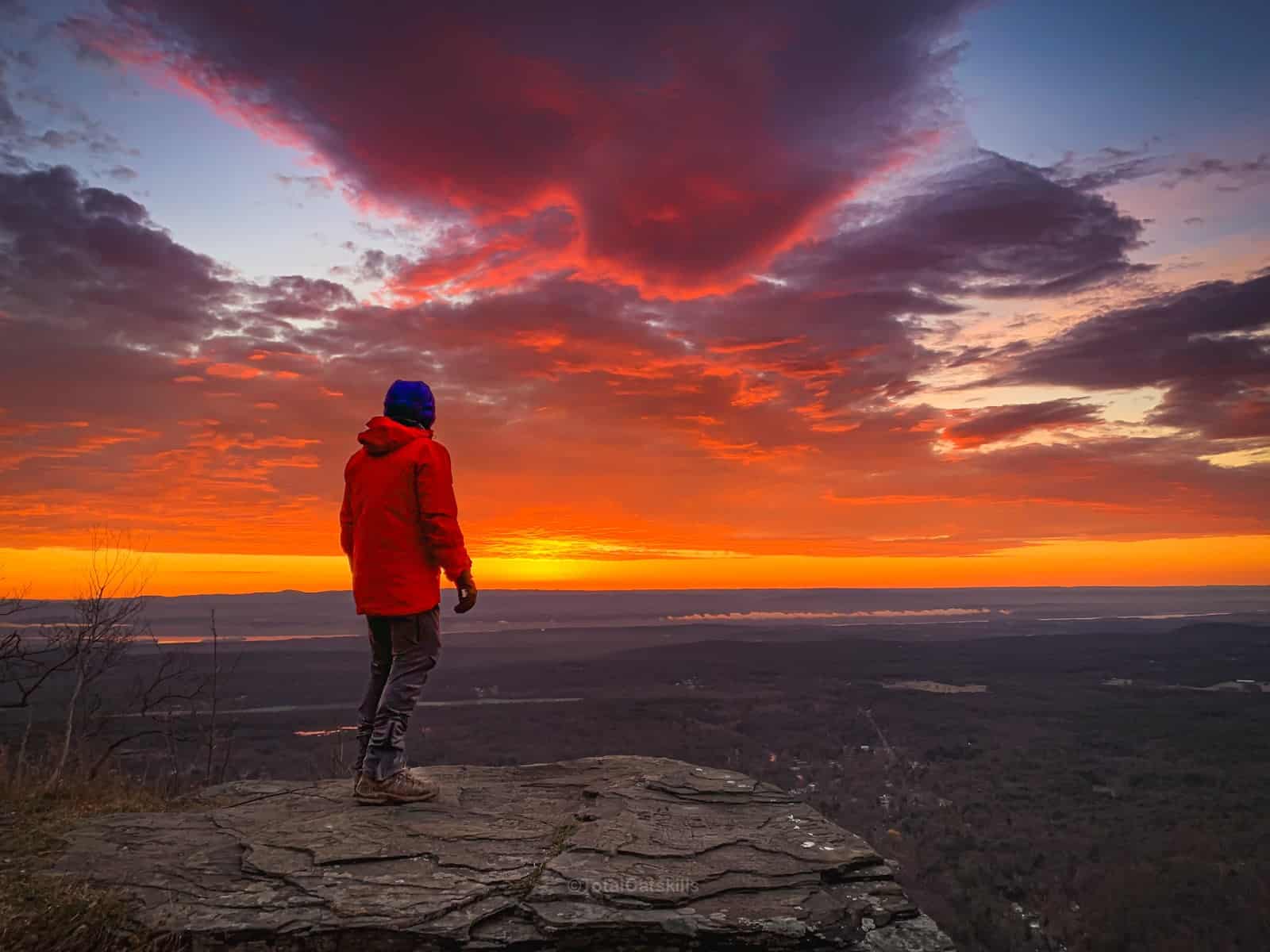 hiker faces east for sunrise