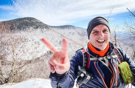hiker extending two fingers on a winter mountain hike